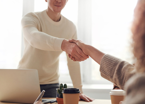 a man and a woman shaking hands in a business transaction.